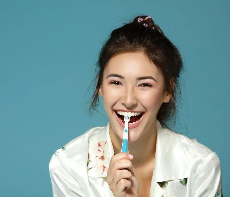 Happy woman brushing her teeth — dental clinic in Buderim, QLD